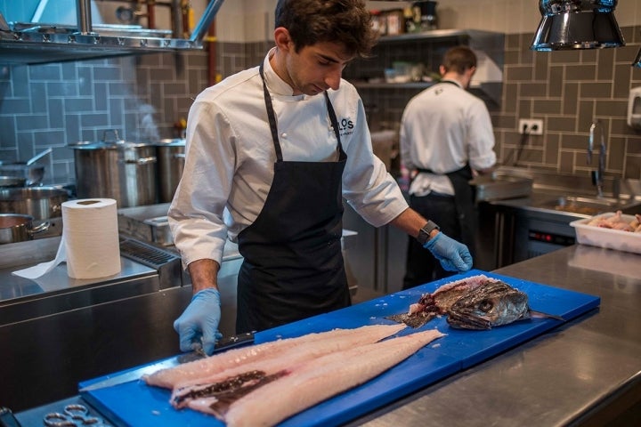 El chef Infantes preparando el pescado en la cocina.