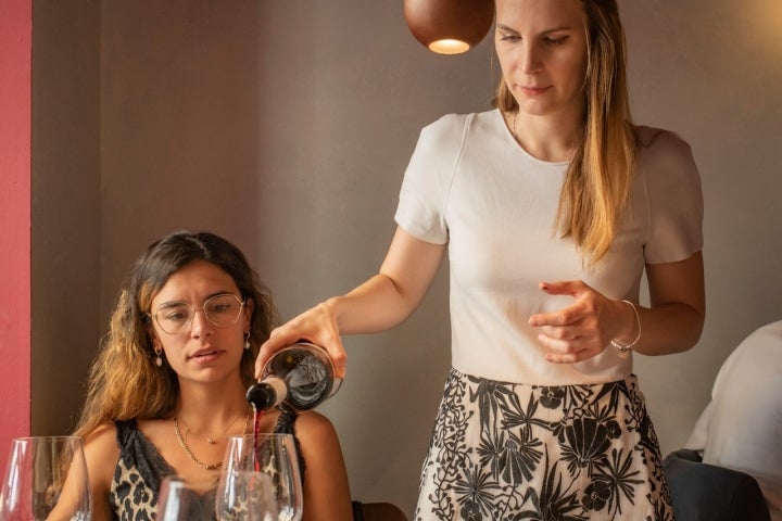 Charlotte sirve una copa de vino.