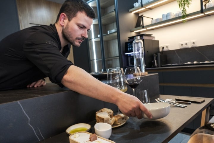 El chef sirve uno de los primeros pases a los comensales de la barra.