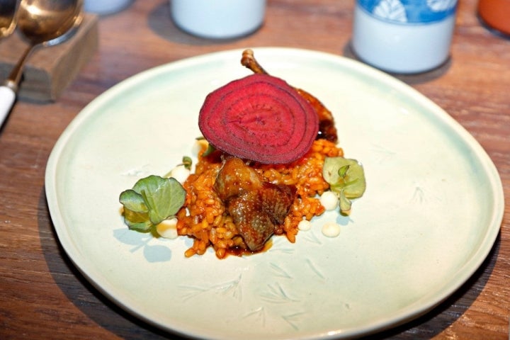 Arroz de pichón con sus muslitos en su propio jugo, berros rojos y una emulsión de romero con ajo.