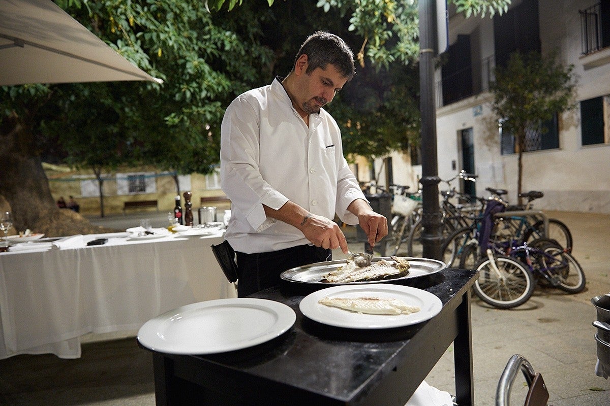 En la terraza, preparando el pescado antes de servirlo.