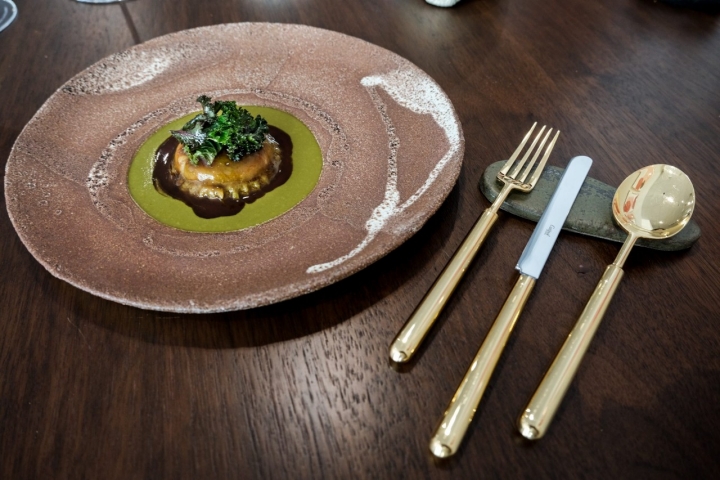 Ravioli de ragú de corzo en salsa de kale al palo cortado.