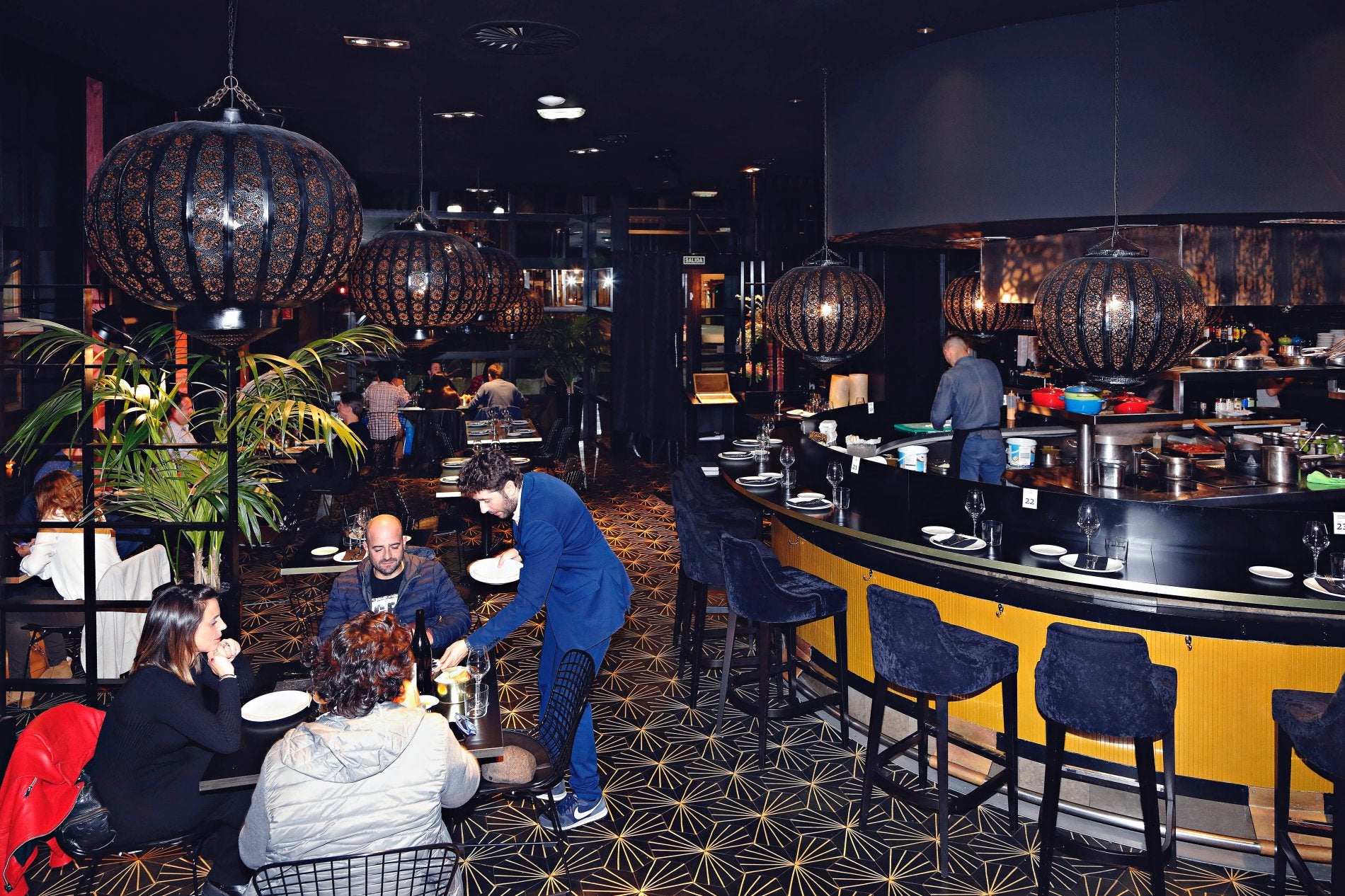 Un espacio moderno, ambientado en tonos oscuros y dorados, donde comer de tapas y raciones en el centro de Gijón.