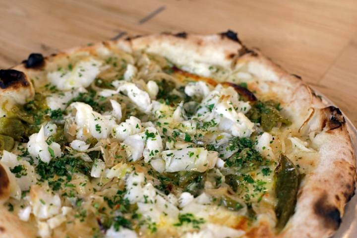Pizza con pinta irresistible: bacalao, queso tierno, pimiento verde y cebolla asados.
