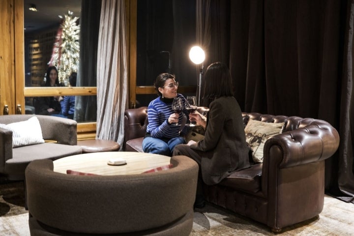 Dos mujeres brindan en un sofá Chester donde arranca la experiencia de Ibaya.