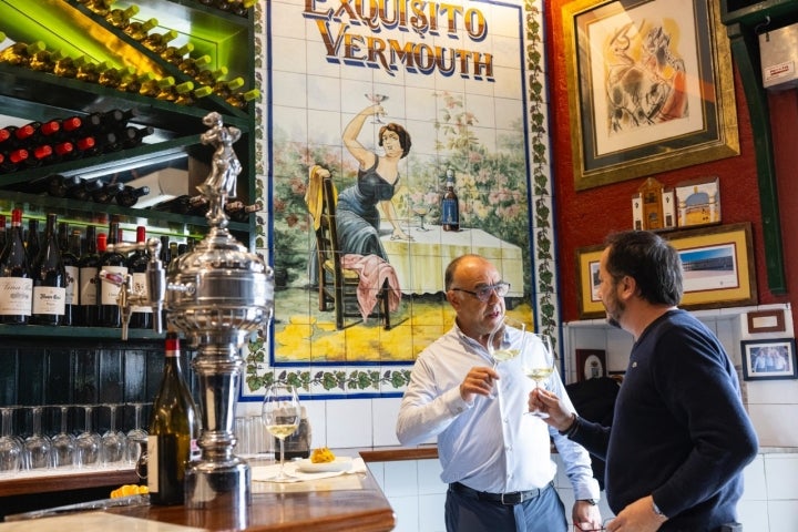 Dos hombres toman un vino en el restaurante.