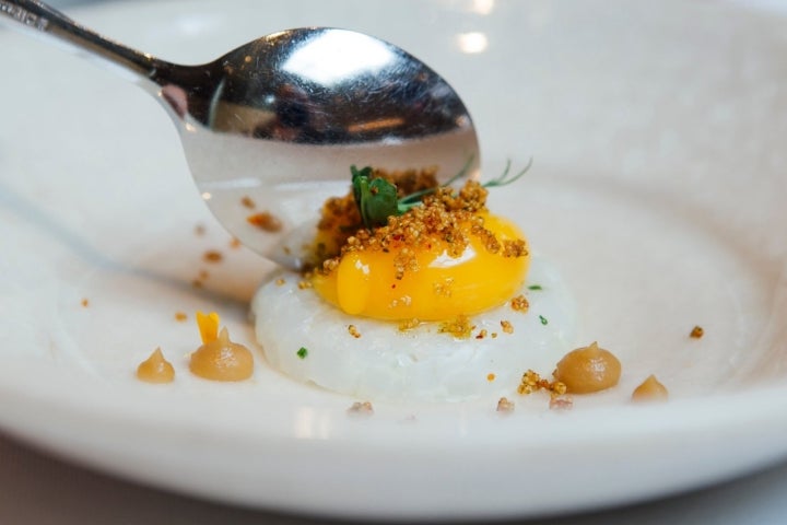 Tartar de calamar con yema de huevo líquida, consomé de cebolla y 'kaffir'.