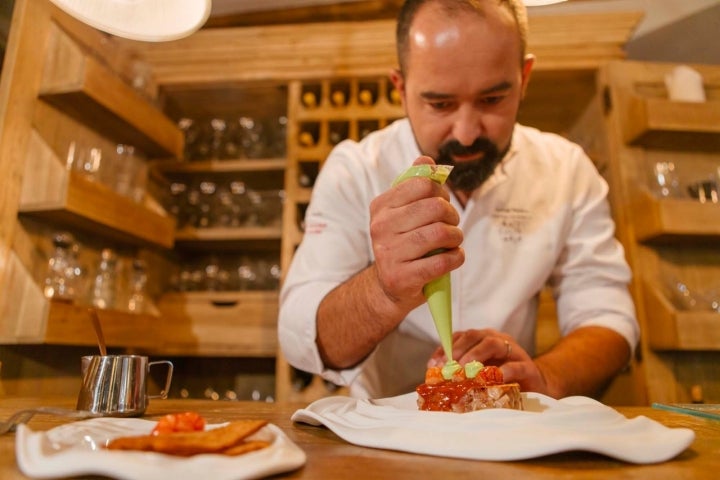 Samuel Moreno emplatando la careta de cerdo con salsa brava suave y carabineros.