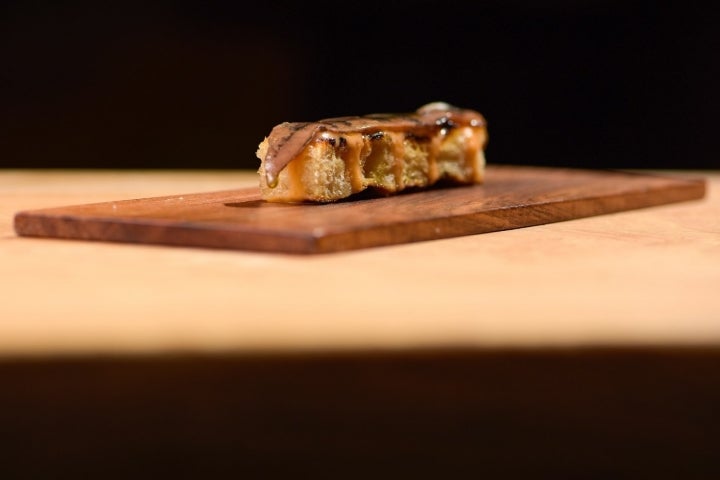 La Anchoa Sanfilippo se sirve en plato de madera y solo lleva salsa de tomate.