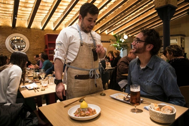 Pablo presenta a uno de los comensales el tartar de pescado del Mediterráneo.