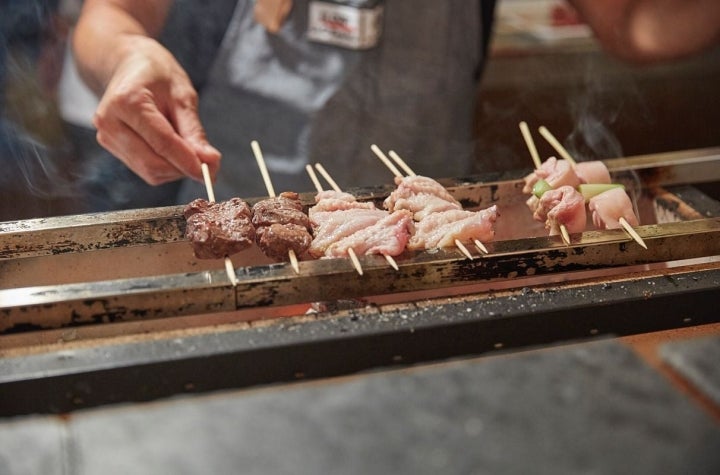 Detalle de la parrilla y las brochetas que forman el kushiyaki, las nueve brochetas en el restaurante pop up del chef Olabegoya en Poble Sec (Barcelona).