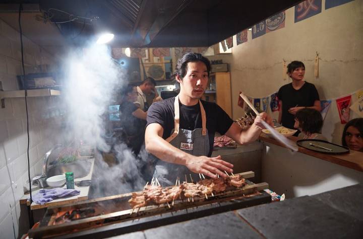 El cocinero Luis Chang maneja la barbacoa del restaurante pop up de barbacoa japonesa del chef Aitor Olabegoya en Poble Sec (Barcelona).