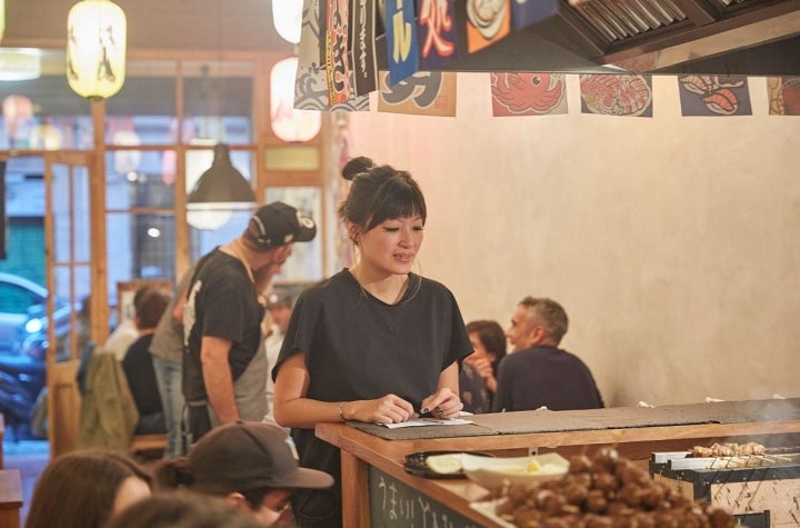 Una camarera espera en la barra del restaurante pop up del chef Aitor Olabegoya en Poble Sec (Barcelona).