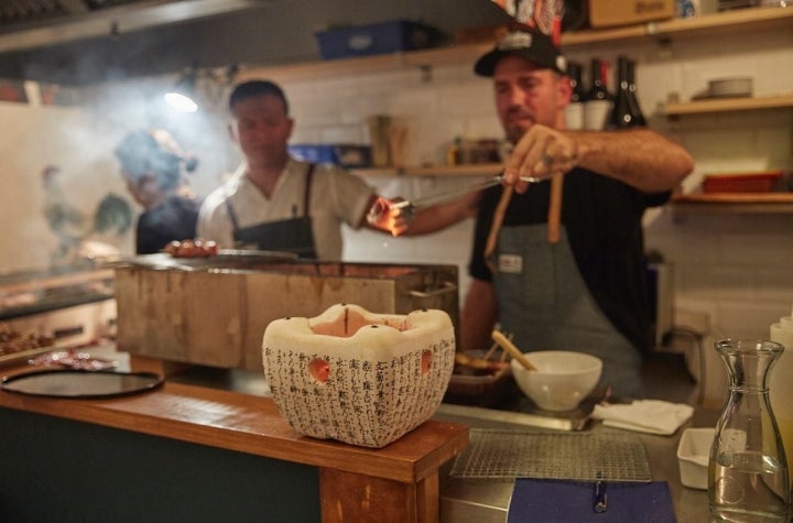 El chef Aitor Olabegoya echa ascuas en un recipiente de cocina japonesa en el restaurante pop up, en Poble Sec (Barcelona).