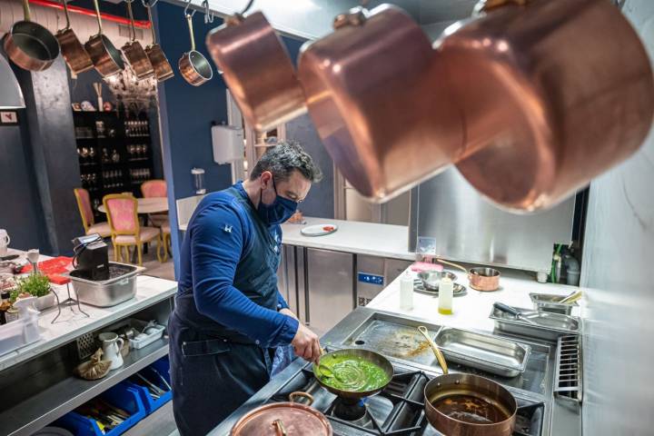 Iker prepara platos frente a las cacerolas de cobre que suele emplear.