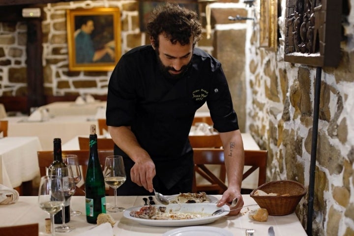 El nieto de Joxe Mari, Mikel Manterola, del 'Bodegón Joxe Mari', trinchando el besugo, en Orio (Guipúzcoa).