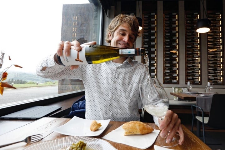 Iñaki Zendoia en la sala del 'Katxiña', en Orio (Guipúzcoa) sirviendo vino de su bodega.