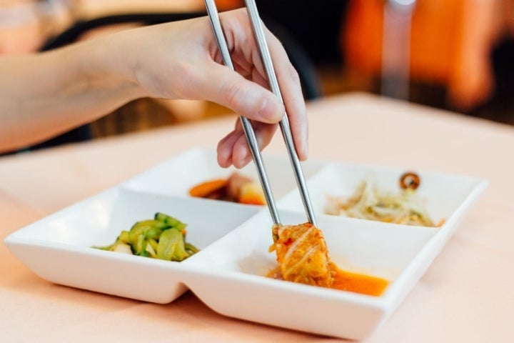 Pinzando kimchi preparado con la receta del pueblo de Joo Lee, del plato de banchan en el restaurante coreano 'Seoul', en Barcelona.