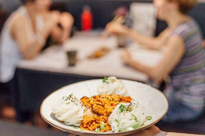 Plato de Kimchi bokum gucsu o fideos y lomo de cerdo salteado del restaurante coreano Seoul, en Barcelona.