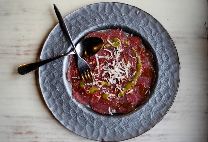 Carpacho de ternera de la región con virutas de queso y balsámico.