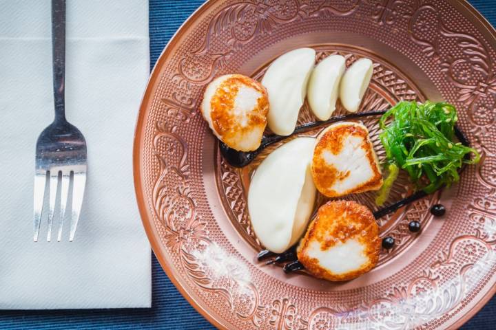 Vieiras con mantequilla y purés de coliflor y ajo negro, "un plato afrancesado" de 'Arte y Solera'.