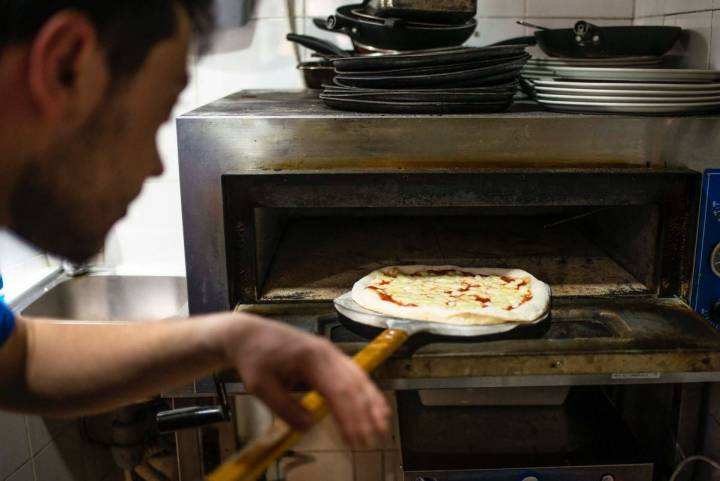 Mikele Corsalini metiendo la pizza margarita en el horno de 'La pizza è bella', en Madrid.