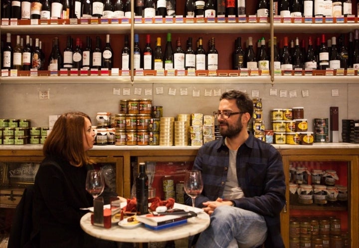 Vinos y latas de conservas en las paredes para degustar.