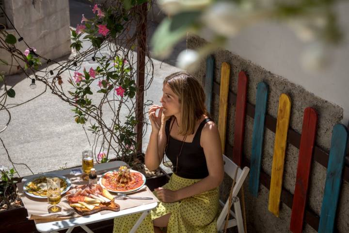 Una chica comiendo en una terraza.