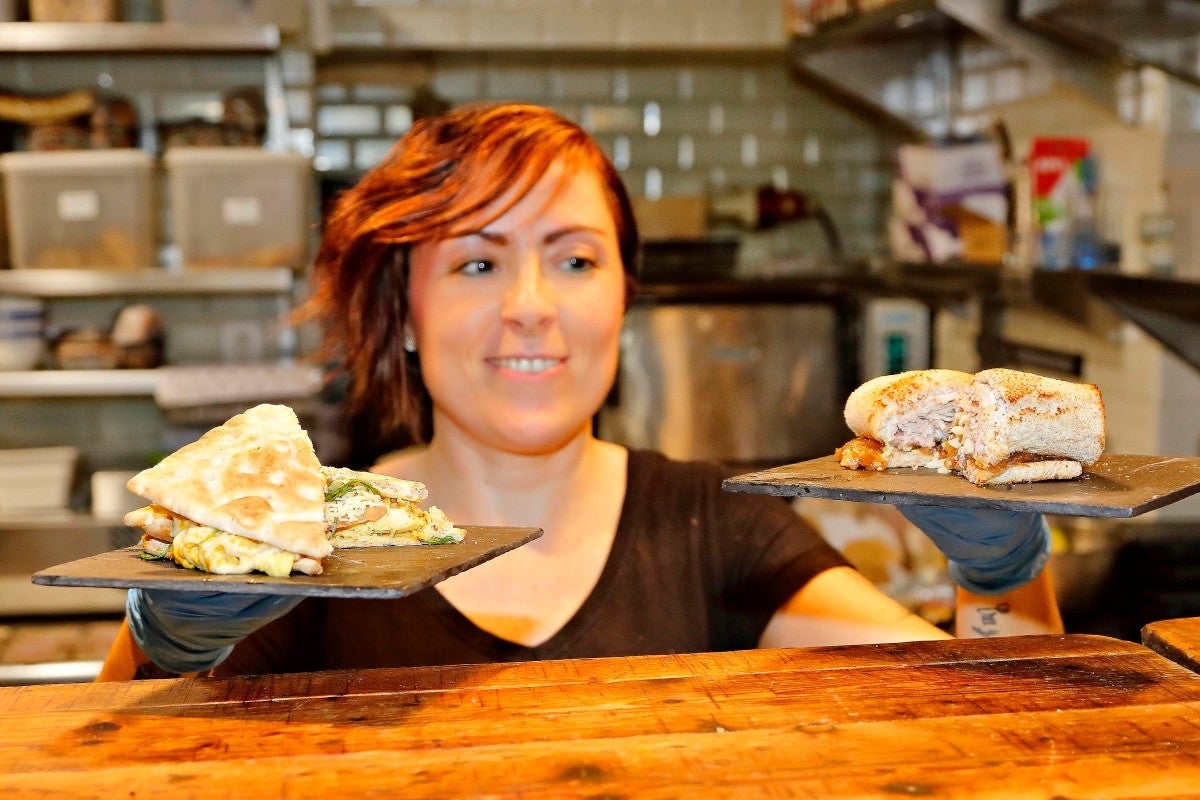 El propietario de la sandwichería 'Craft 19', en el Mercado de Vallehermoso, Madrid, con uno de sus sándwiches.