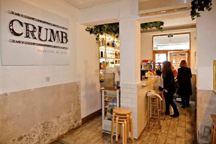 Vista del interior de la sandwichería 'Crumb', en Madrid, y del ambiente de los clientes en la barra del local.