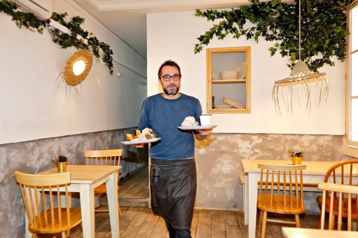 El dueño del local 'Crumb', en Madrid, recogiendo una mesa.