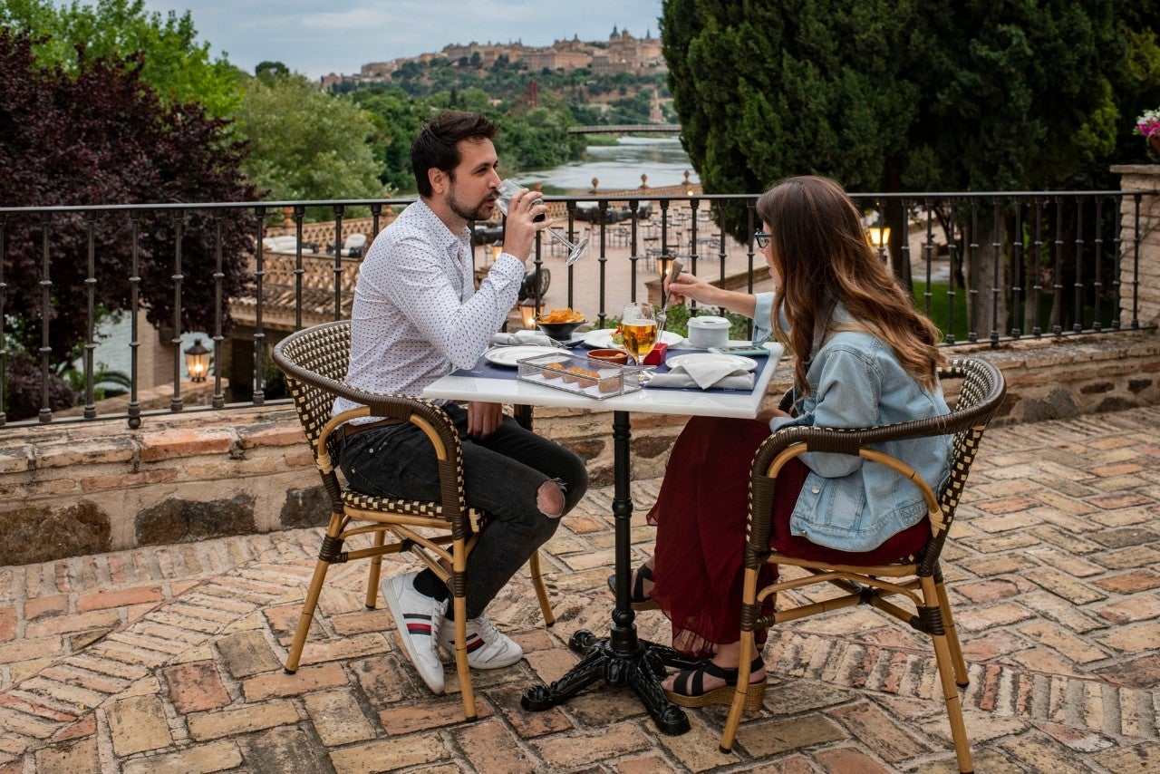 Una pareja disfruta de un picoteo con unas vistas envidiables sobre Toledo.