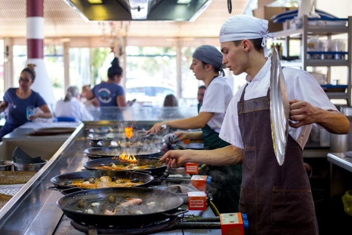 Los encargados de hacer del arroz en el Escribà comparten espacio con los clientes.