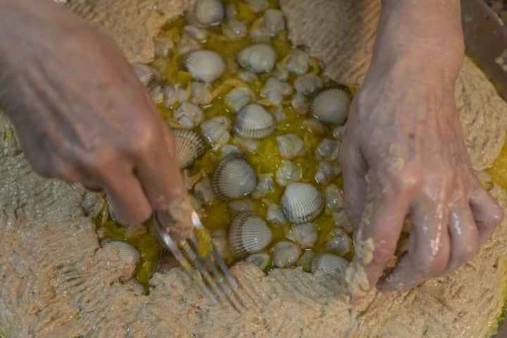 Empanada de maíz y berberechos cerrando masa