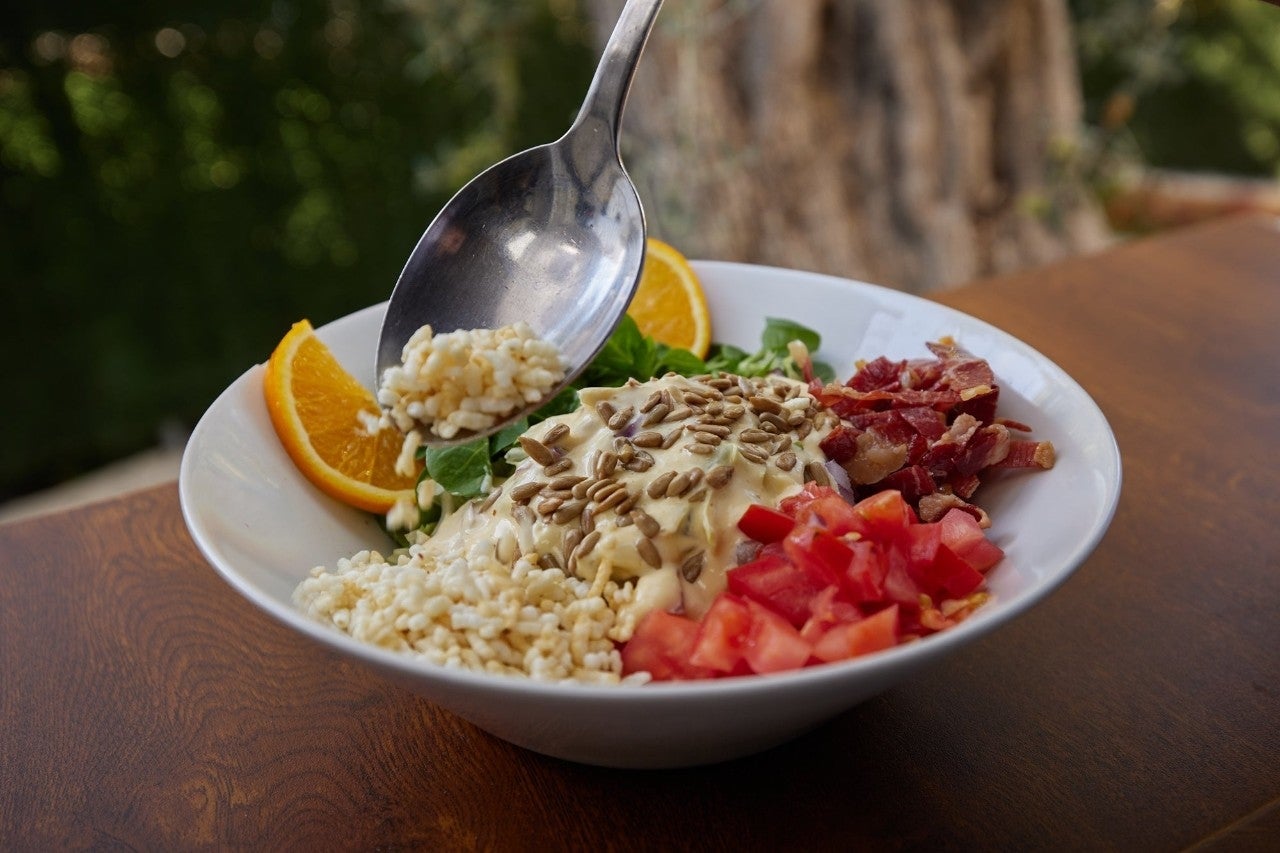 Ensalada con arroz inflado casero, tomate natural, jamón, pipas y mayonesa de cítricos