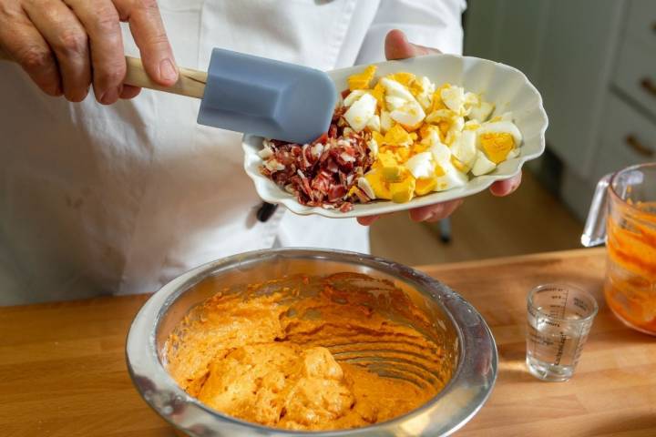 Echando los trocitos de jamón y huevo duro a la masa del bizcocho de salmorejo.