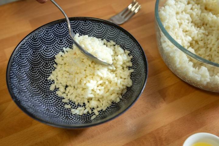 Colocando el arroz cocido en uno de los bowls de los pokes hawaianos.