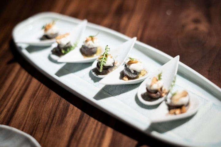 Anchoas de l’Escala sobre stracciatella y almendra garrapiñada.