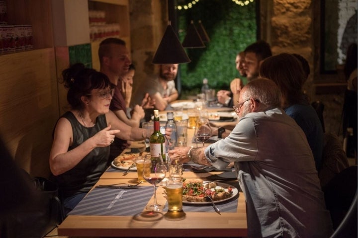 Compartiendo triángulos de 'pizza' en el comedor y tan a gusto como en casa. Foto: Demaio Pizza.