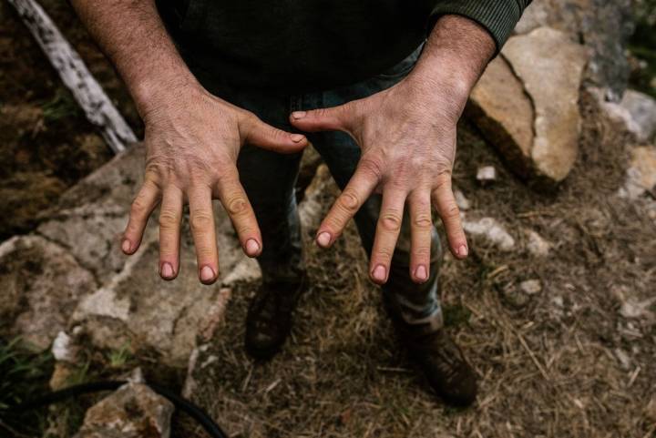 Manolo muestra sus manos ajadas y cubiertas de tierra, prueba del duro trabajo que requieren las fincas.