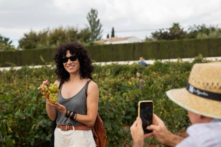 Una chica muestra a cámara un racimo de moscatel