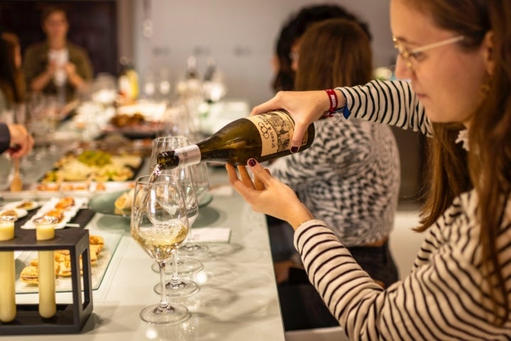 Una chica sirve una copa de vino verdejo.