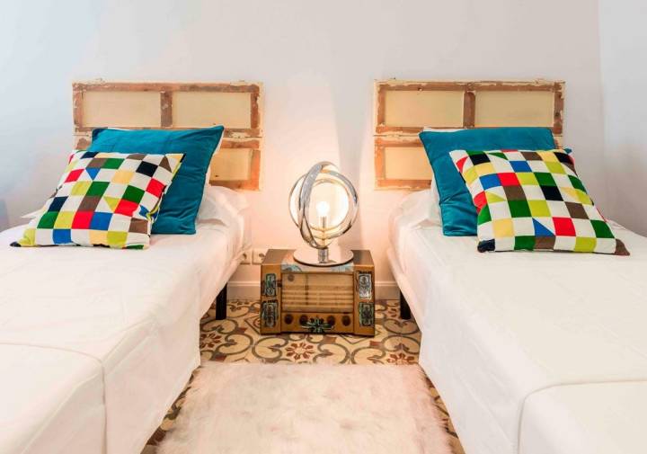 Dos camas individuales con una mesilla y una lámpara en medio