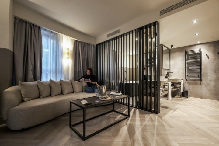 Una mujer descansa en el sofá de una de las suites de Casa Serras.