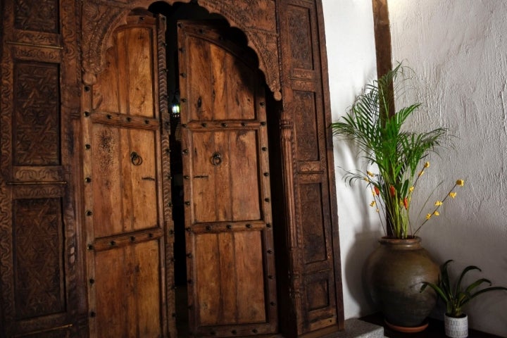 Puerta de Palosanto de India con planta de kentia.