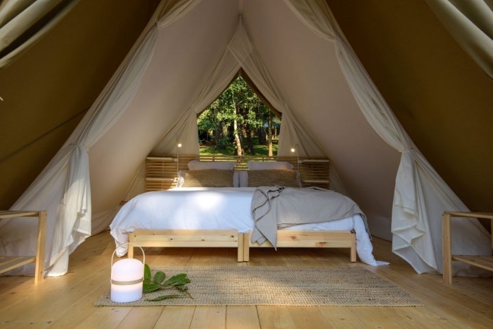 Cama de una de las cabañas del glamping Amaraxe, en Porto do Son