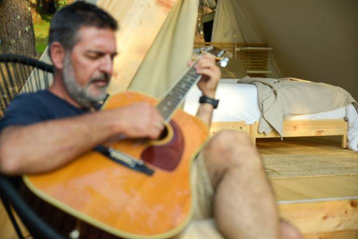 Un cliente tocando la guitarra en el glamping Amaraxe, en Porto do Son