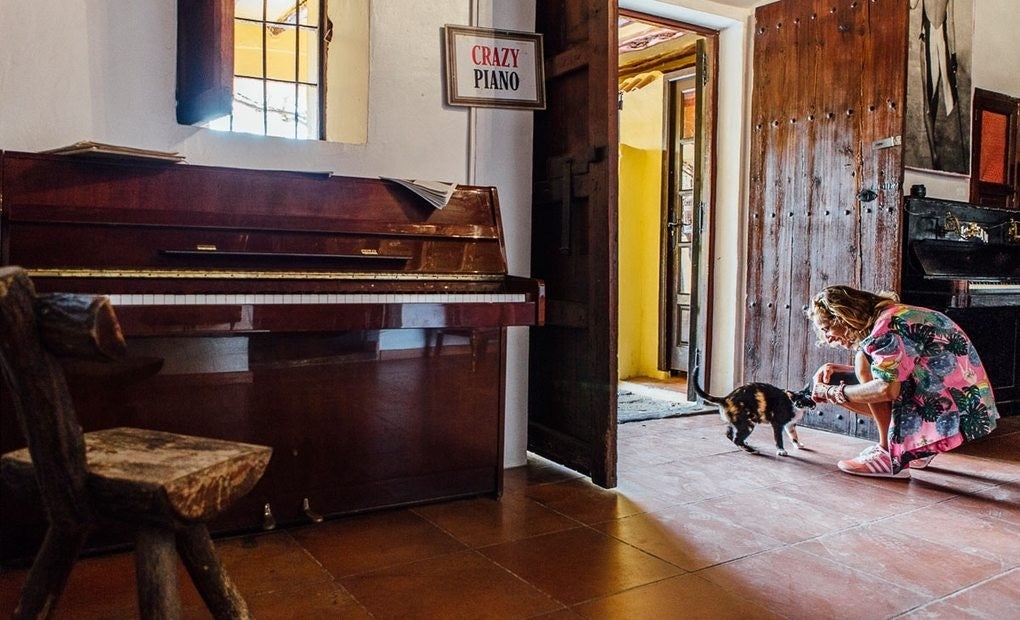 Sofía, una de las empleadas, acaricia uno de los gatos de Anthony Pike, en el hall de entrada a la habitación de Freddie Mercury