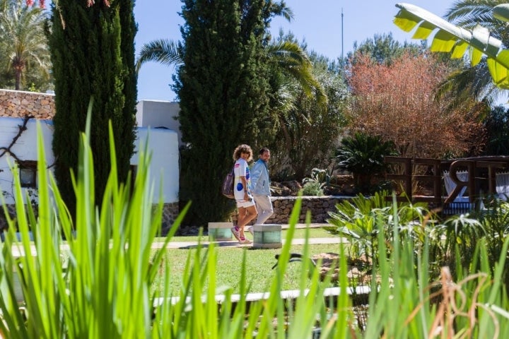 Una pareja pasea entre las fuentes y las flores de la finca.