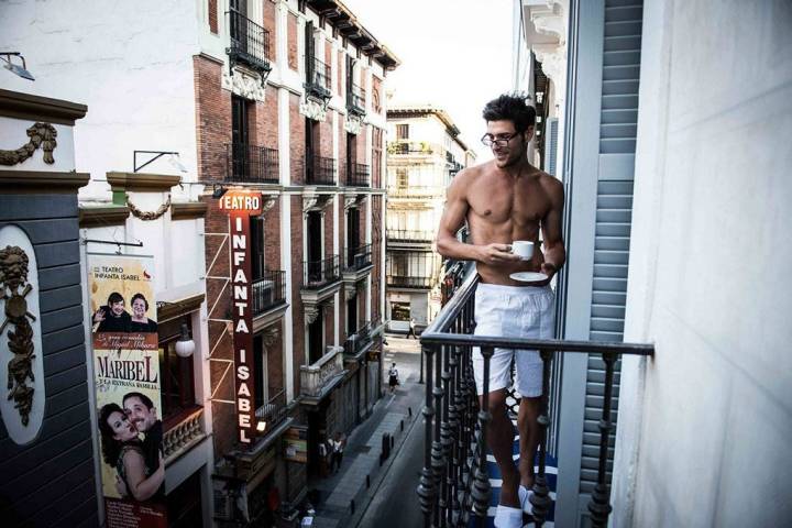 Hombre en el balcón de una de las habitaciones del hotel tomando un café